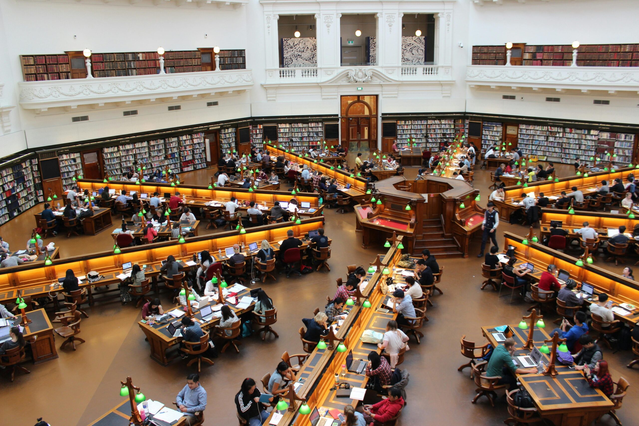 Aerial view of a bustling study hall in a university library with students studying.