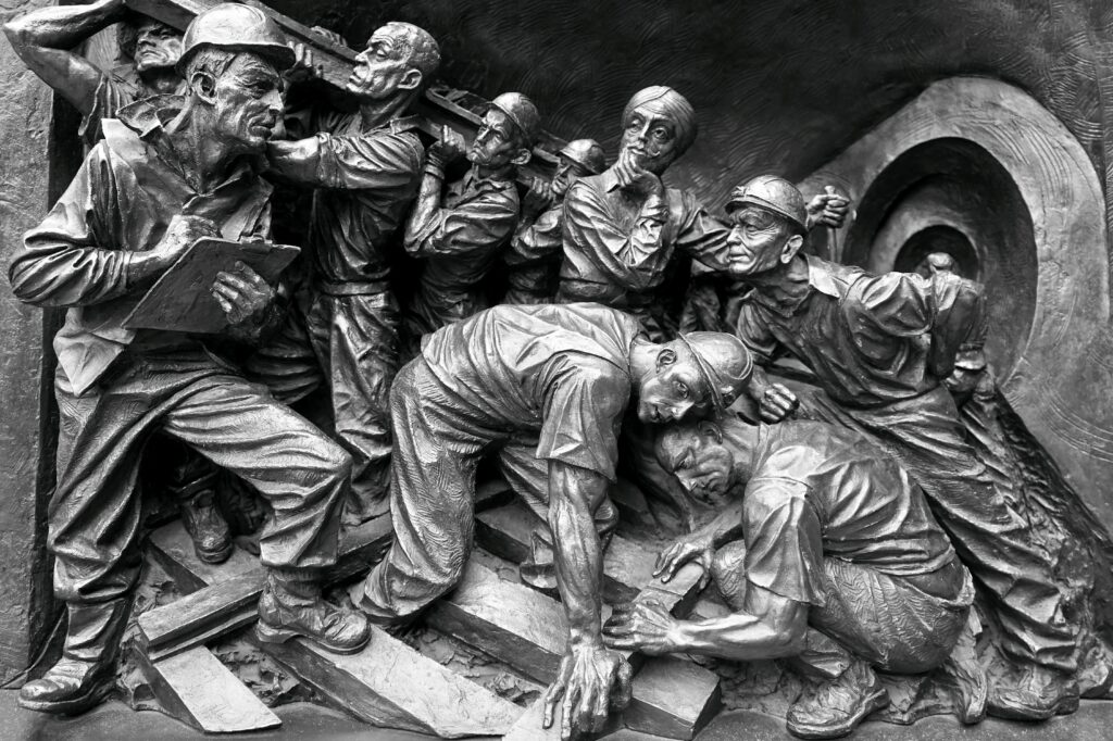 Detailed relief showing a group of miners in action, capturing the essence of teamwork and labor.